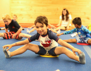 a boy stretching on the mats
