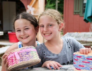 two girls smiling with their homemade baskets
