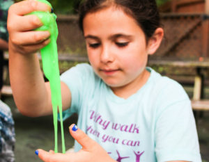 a girl playing with green goo