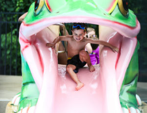 a young boy getting ready to slide down a little waterslide