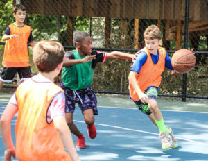 A boy dribbling a basketball against an opponent