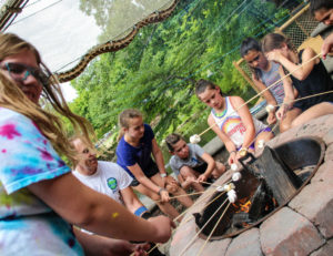 a group of campers roasting marshmallows