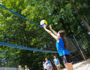 a girl serving a volleyball