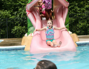 A young girl sliding down a little waterslide