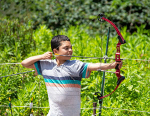 A boy aiming his bow and arrow