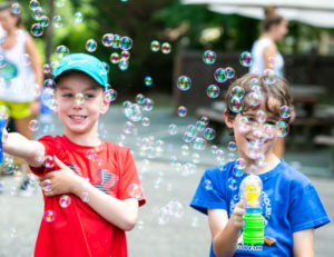 two boys playing with bubble makers