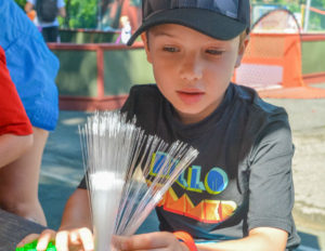 a boy playing with flimsy spiked tubes