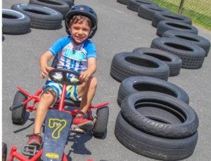 A boy happily pedaling his kart