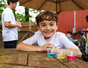 a boy smiling at the camera before an experiment