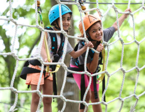 two girls climbing a net