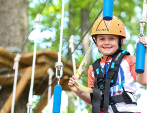 a boy smiling on an obstacle course