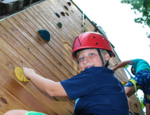 a boy looking down at the camera while climbing