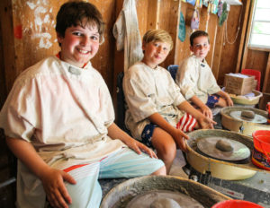 three boys in pottery class
