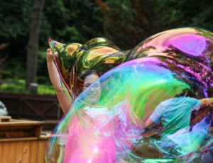 a girl manipulating a giant bubble