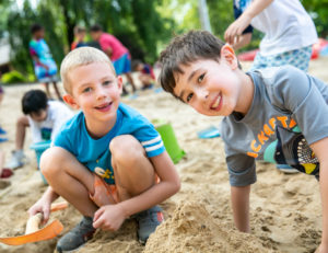 two boys digging in sand